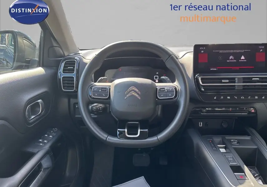 Vue intérieure frontale du poste de conduite du Citroën C5 Aircross noir, avec volant multifonction et écran tactile central.