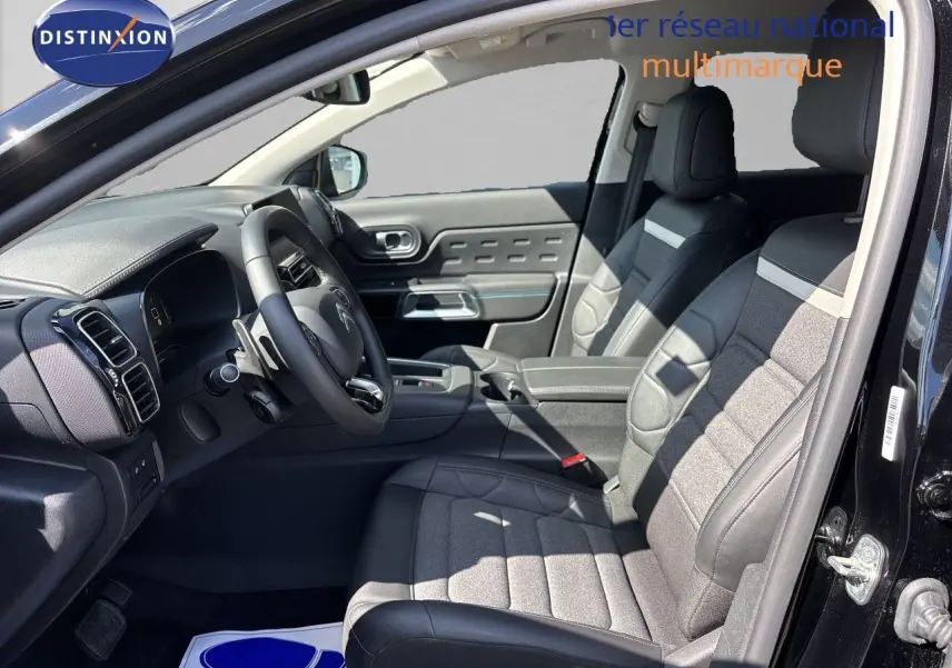 Vue intérieure côté conducteur du Citroën C5 Aircross noir Perla Nera, montrant sièges tissu et cuir et tableau de bord moderne.