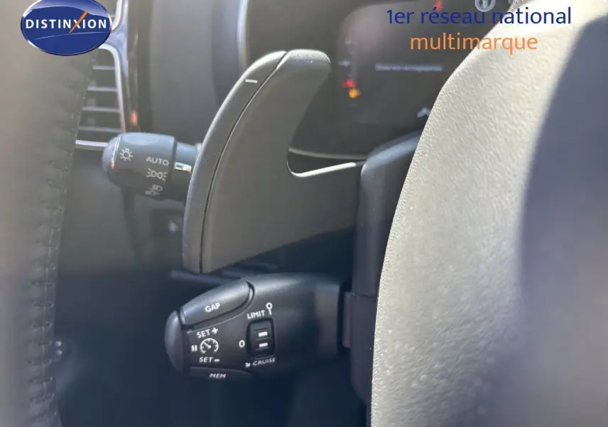 Gros plan sur la commande de régulateur de vitesse et palette de changement sur le volant d’un Citroën C5 Aircross noir.