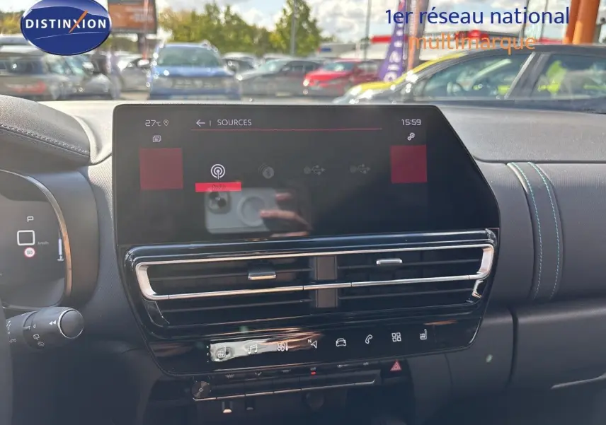 Vue intérieure du tableau de bord du Citroën C5 Aircross 2025, écran tactile central et aérateurs avec surpiqûres bleues.