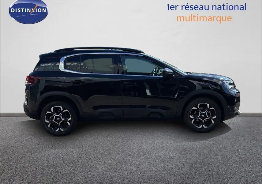 Vue de profil côté gauche d'un Citroën C5 Aircross 2025 noir Perla Nera métallisé avec jantes alliage distinctives.