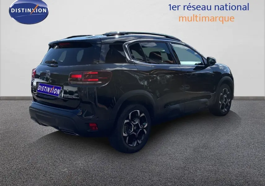 Vue 3/4 arrière droite d'un Citroën C5 Aircross noir Perla Nera métallisé avec jantes bi-ton et vitres teintées.