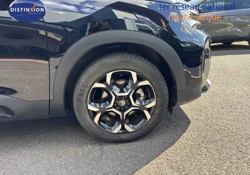 Gros plan sur la roue avant gauche d’un Citroën C5 Aircross noir Perla Nera avec jante alliage distinctive.