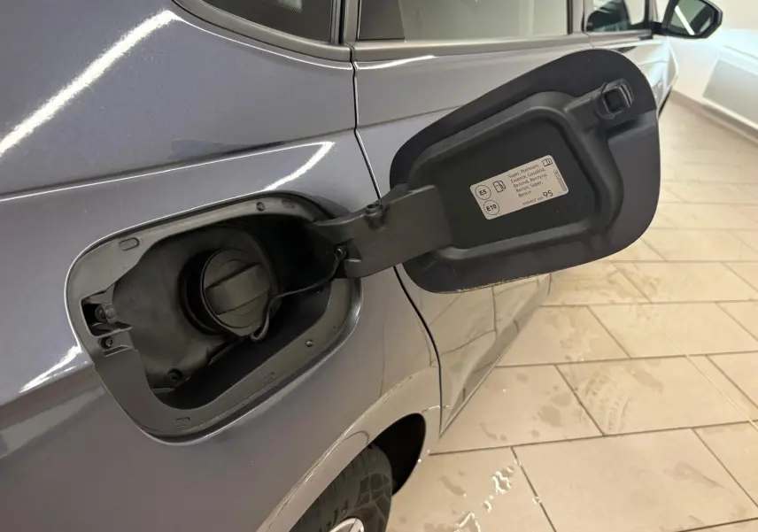 Vue rapprochée du côté gauche arrière d’une Volkswagen Polo gris cendre 2024 avec trappe à carburant ouverte.