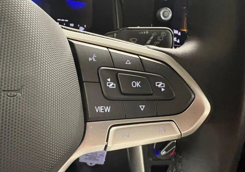 Gros plan sur les commandes multifonctions au volant de la Volkswagen Polo gris cendre 2024, version Life Plus.