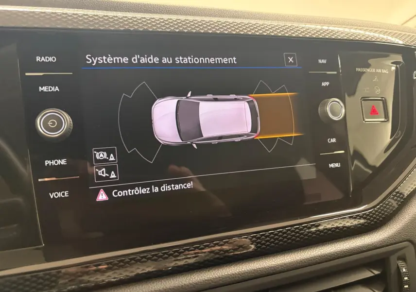 Écran central montrant le système d'aide au stationnement actif dans une Volkswagen Polo gris cendre 2024.