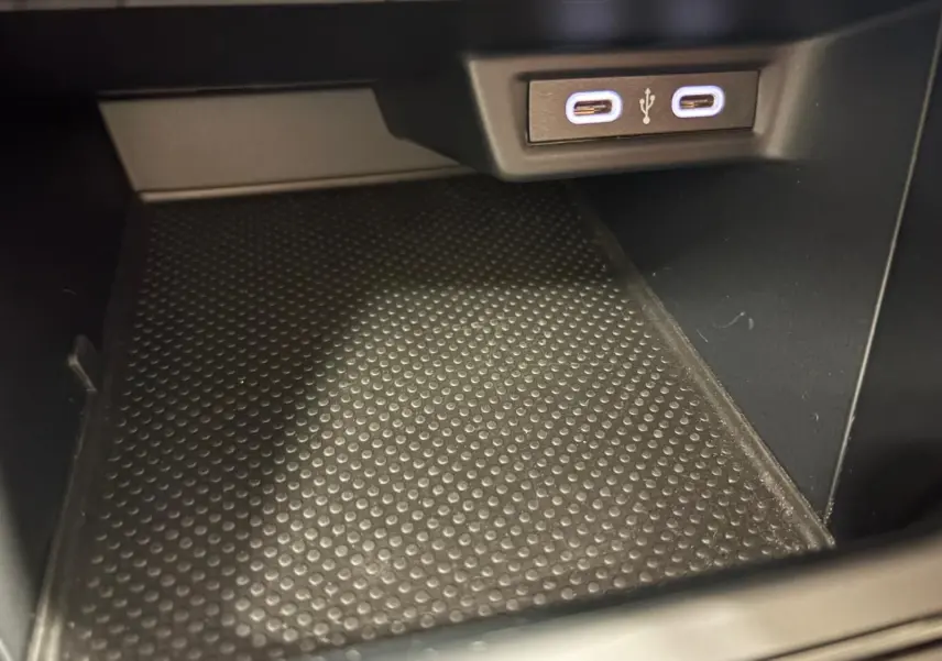 Gros plan sur la prise USB double et le tapis antidérapant noir dans le rangement intérieur de la Volkswagen Polo gris cendre 2024.