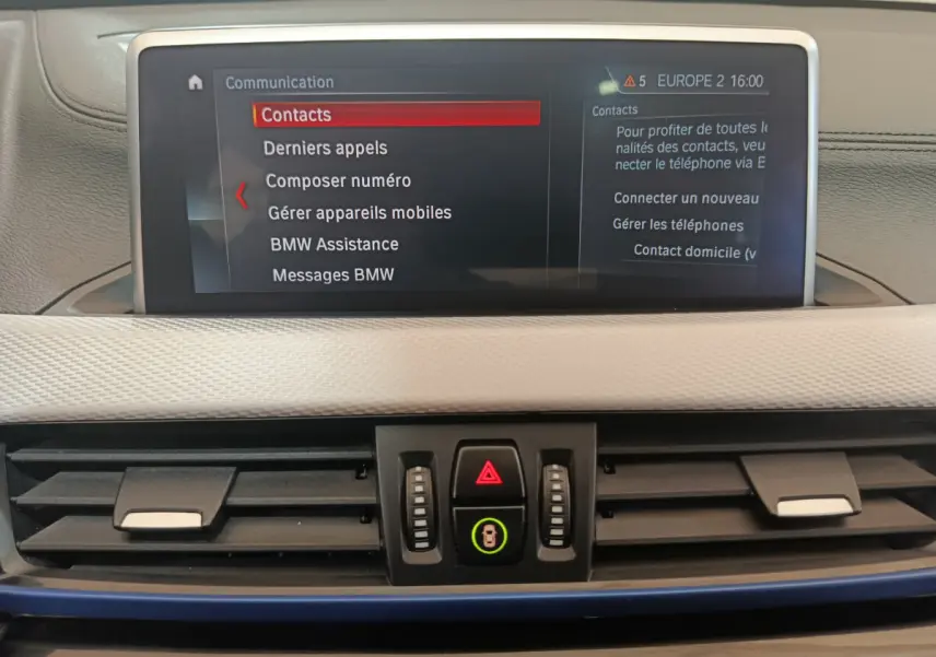 Écran tactile central affichant le menu communication dans l'habitacle beige du BMW X1 sDrive18i M Sport 2019.