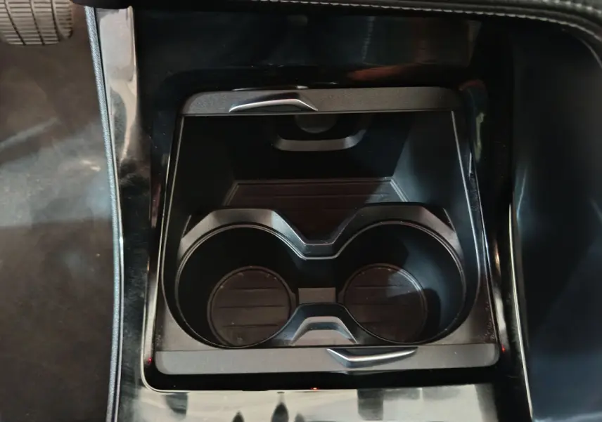 Gros plan sur les porte-gobelets centraux noirs du BMW X1 sDrive18i M Sport DKG7, intérieur sombre.