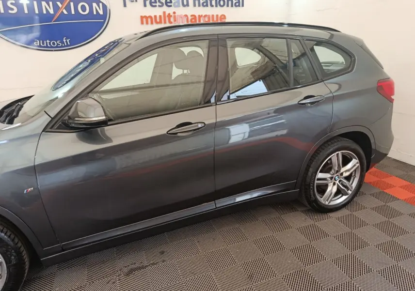 BMW X1 sDrive18i M Sport gris foncé vue de profil côté gauche avec jantes alliage et logo M Sport sur aile avant