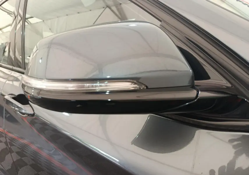 Rétroviseur côté gauche gris métallisé de BMW X1 sDrive18i M Sport 2019 avec clignotant intégré, vue rapprochée.