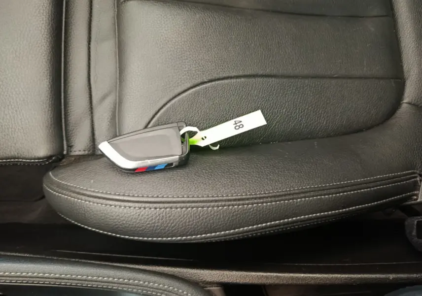 Clé BMW posée sur un siège en cuir noir à surpiqûres blanches, intérieur du BMW X1 sDrive18i M Sport 2019.