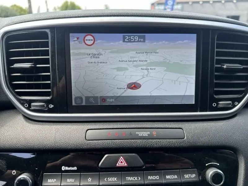 Écran tactile central du Kia Sportage 2021 affichant la navigation avec carte et commandes multimédia en dessous.