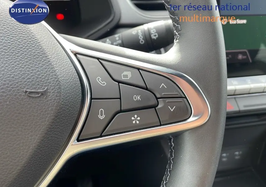Gros plan sur les commandes multifonctions à gauche du volant du Renault Captur gris Cassiopée métal, intérieur moderne.