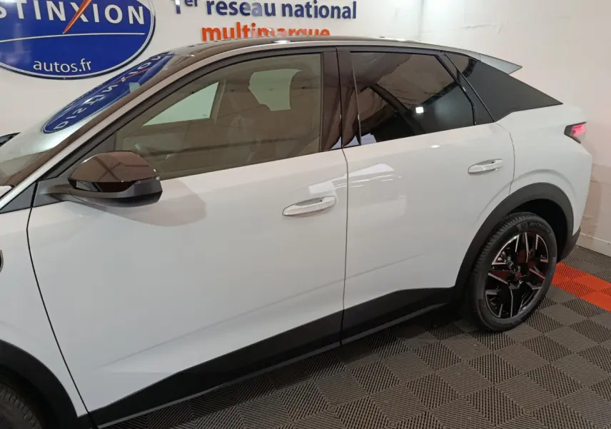 Profil côté gauche du Peugeot 3008 blanc hybride 2025 avec toit noir et jantes alliage noires.