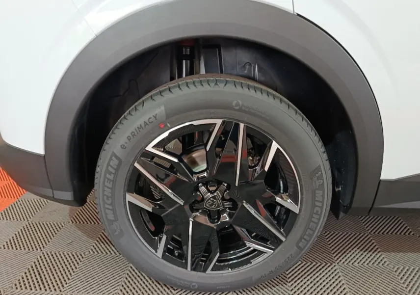 Gros plan sur la roue arrière droite du Peugeot 3008 blanc, avec jante noire brillante et pneu Michelin e.PRIMACY.