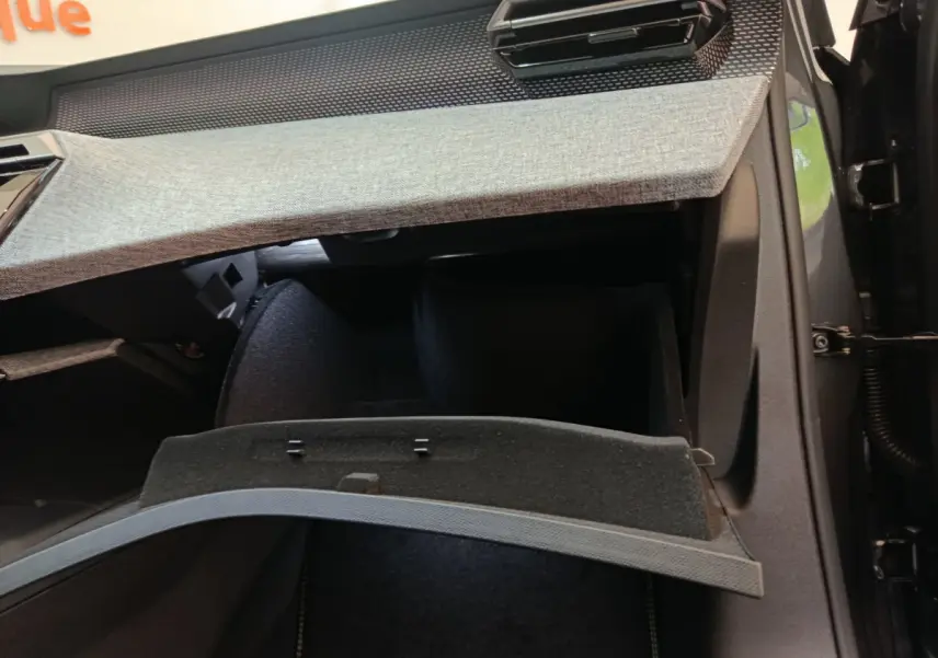 Intérieur du Peugeot 3008 1.2 Hybrid 145 GT montrant la boîte à gants ouverte avec revêtement tissu gris et noir.