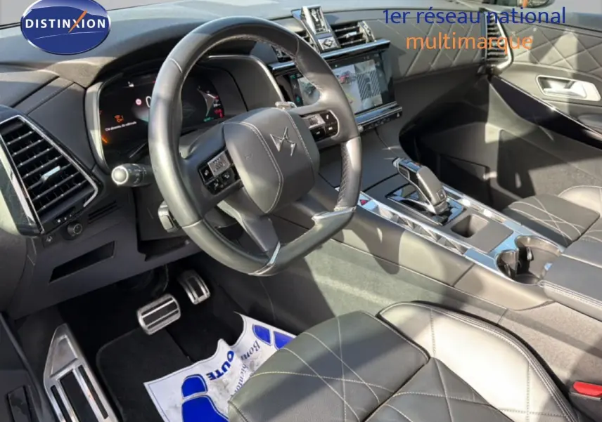 Vue intérieure côté conducteur du DS7 2024 noir perle, mettant en valeur le volant cuir et la console centrale moderne.