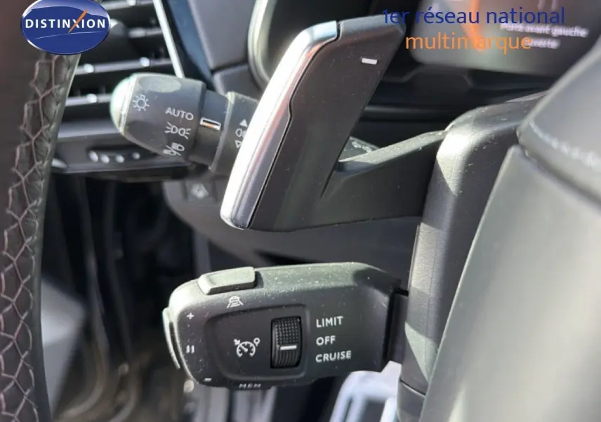 Gros plan sur la commande de régulateur de vitesse à gauche du volant du DS7 noir perle 2024.