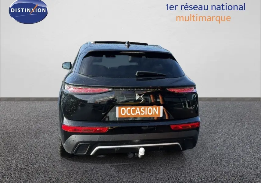 Vue arrière d'un DS7 noir perle 2024 avec feux allongés et attelage visible sur fond neutre.
