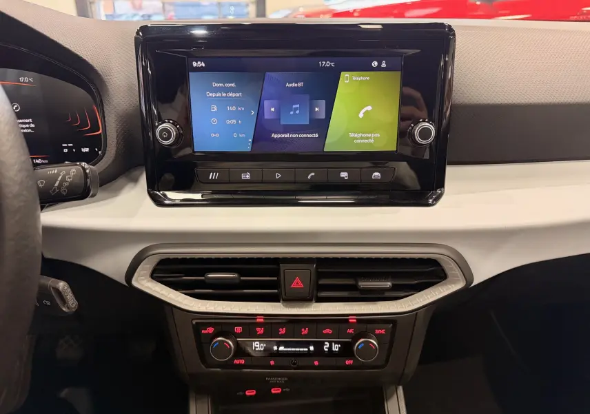 Vue rapprochée de la console centrale de la SEAT Ibiza 2025, écran tactile et commandes de climatisation visibles.