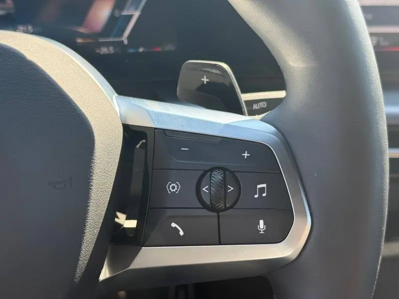 Gros plan sur les commandes gauche du volant cuir multifonction d’une BMW X2 Skyscraper Grey 2025.