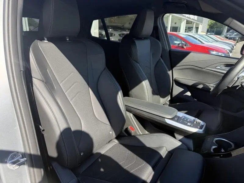 Vue intérieure côté gauche montrant les sièges avant noirs en Alcantara et simili cuir du BMW X2 sDrive20dA 2025.