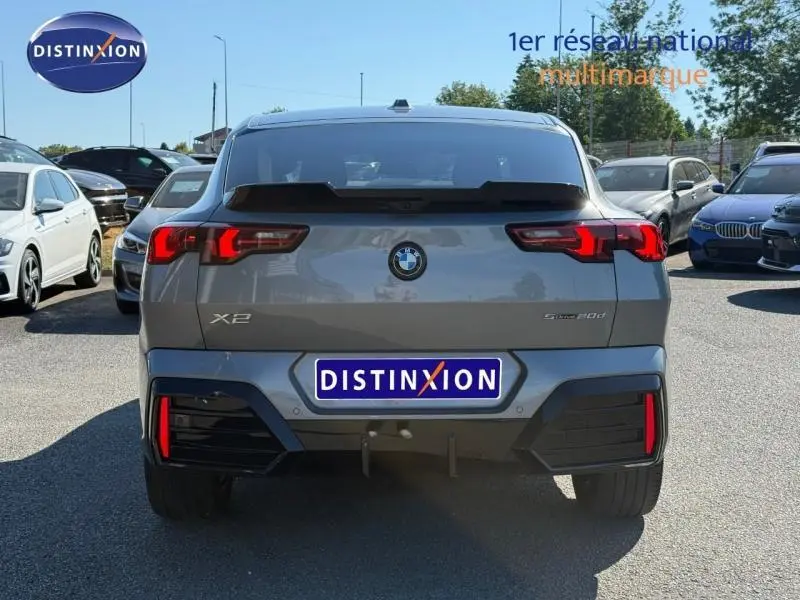 Vue arrière d'une BMW X2 sDrive20dA 2025 en Skyscraper Grey métallisé avec feux LED distinctifs et logo BMW visible.