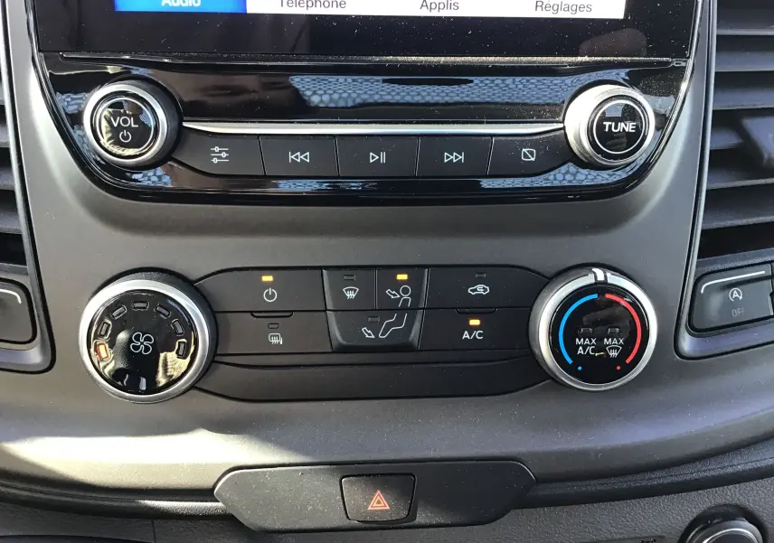 Gros plan sur la console centrale du Ford Transit Chassis Cabine blanc, montrant les commandes audio et climatisation.