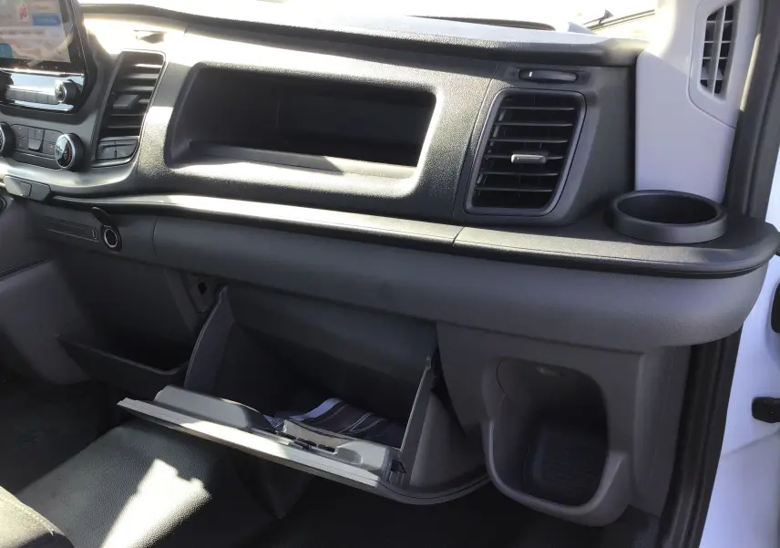Intérieur côté passager du Ford Transit Chassis Cabine blanc 2020, tableau de bord avec boîte à gants ouverte et porte-gobelet.