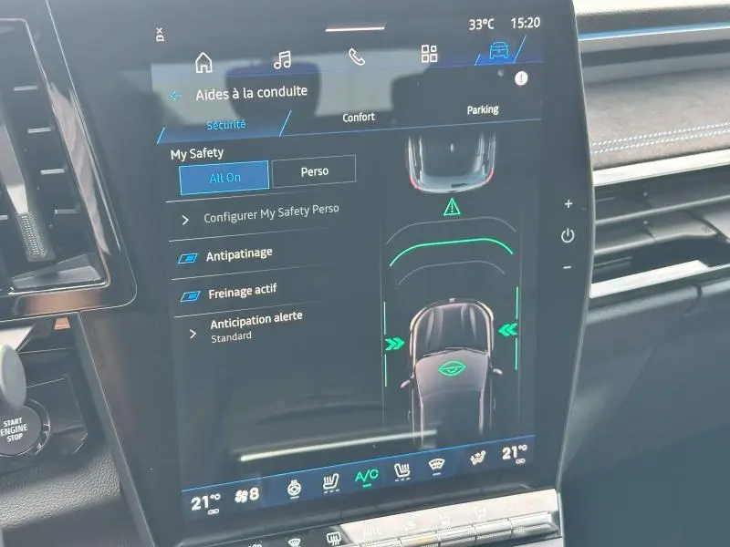 Écran tactile central du Renault Austral gris 2025 montrant les aides à la conduite et la vue de la voiture en mode parking.