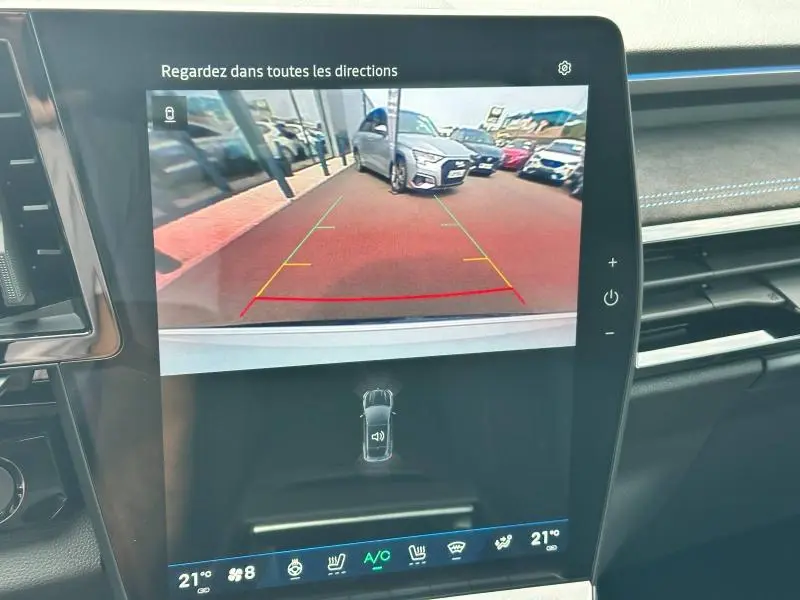 Vue caméra de recul montrant un Renault Austral gris garé côté droit sur un parking extérieur.