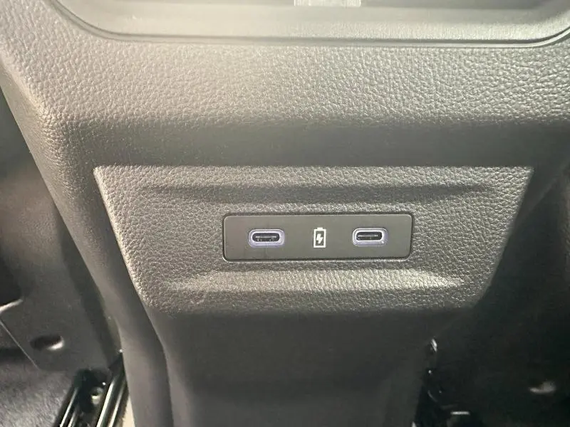 Prise USB-C double noire en gros plan sur la console arrière du Renault Austral gris 2025 hybride.