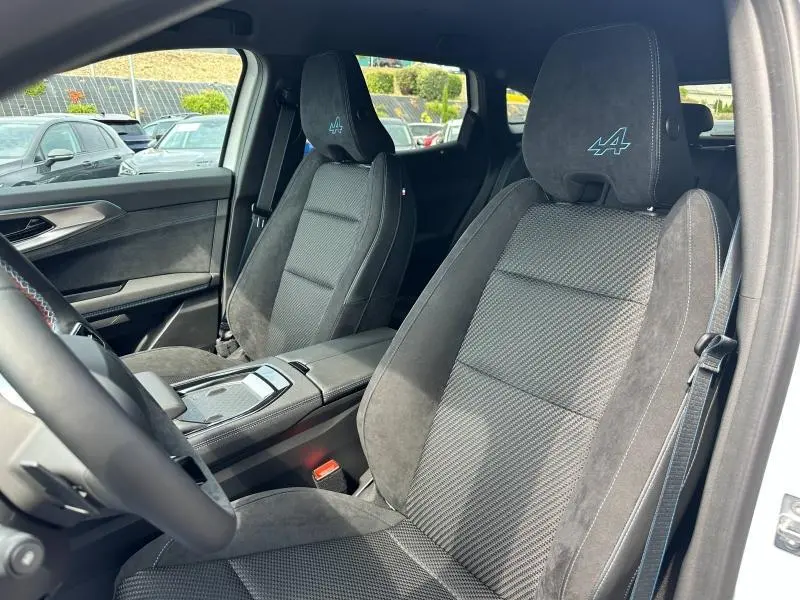 Vue intérieure côté conducteur du Renault Austral gris, sièges sport avec logo Alpine brodé sur appuie-tête.