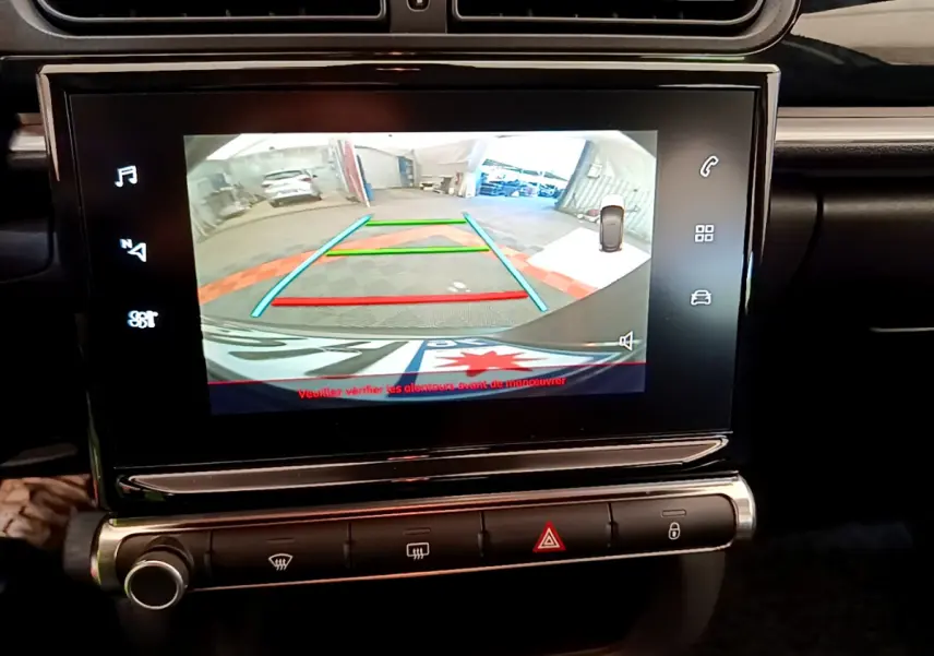 Écran tactile central de la Citroën C3 gris foncé montrant la caméra de recul avec lignes de guidage colorées.