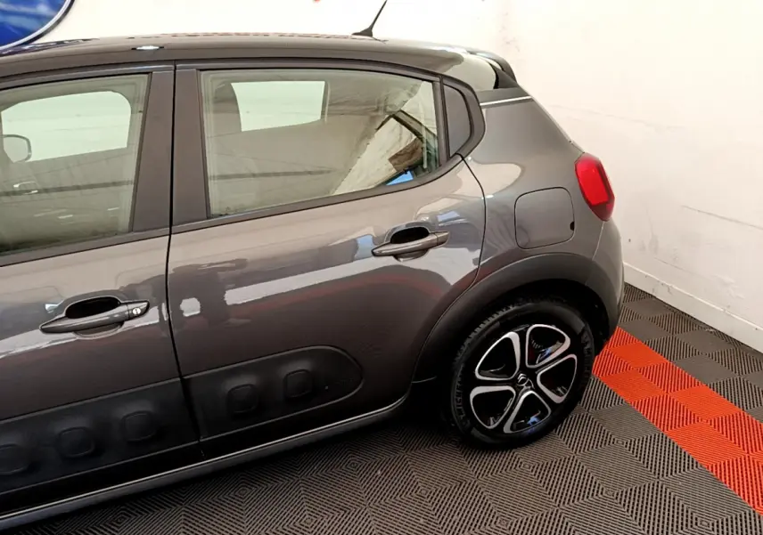 Vue latérale droite d'une Citroën C3 gris foncé avec jantes noires et détails Airbump sur porte arrière.