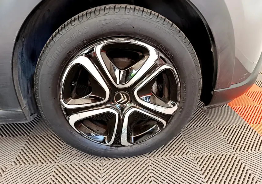 Gros plan sur la roue avant droite gris foncé d'une Citroën C3 2019 avec jante alliage noire et chromée distinctive.