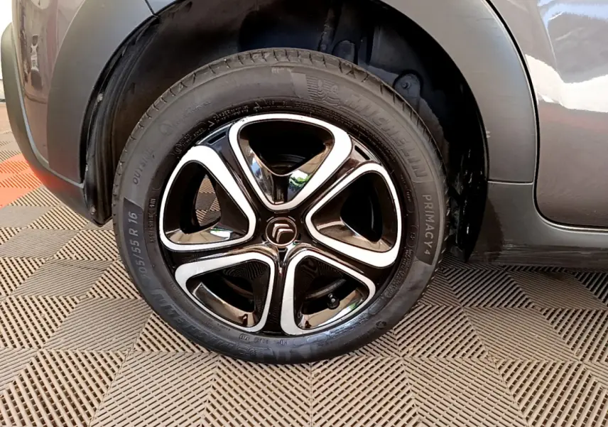 Gros plan sur la roue avant gauche gris foncé de la Citroën C3 PureTech 82 S&S BVM Shine 2019 avec jante noire et argentée.