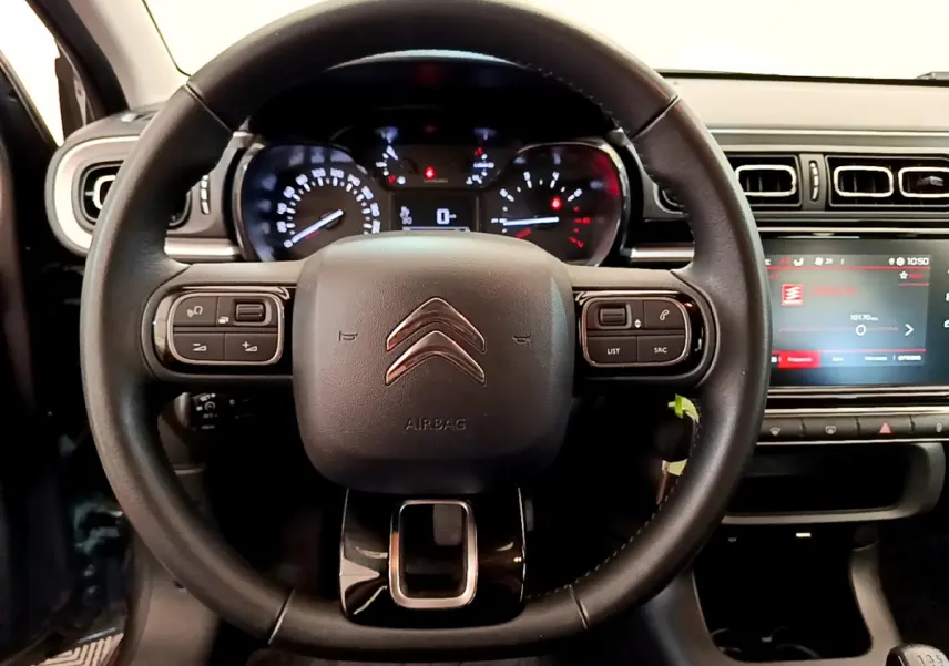 Vue rapprochée du volant cuir noir de la Citroën C3 2019 avec tableau de bord et écran tactile central allumé.