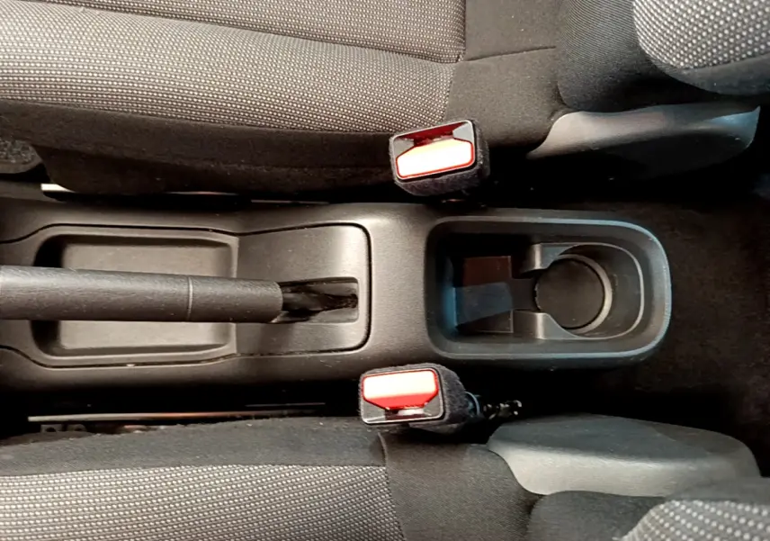 Vue plongeante sur la console centrale noire de la Citroën C3 2019, avec frein à main et porte-gobelet entre sièges gris foncé.