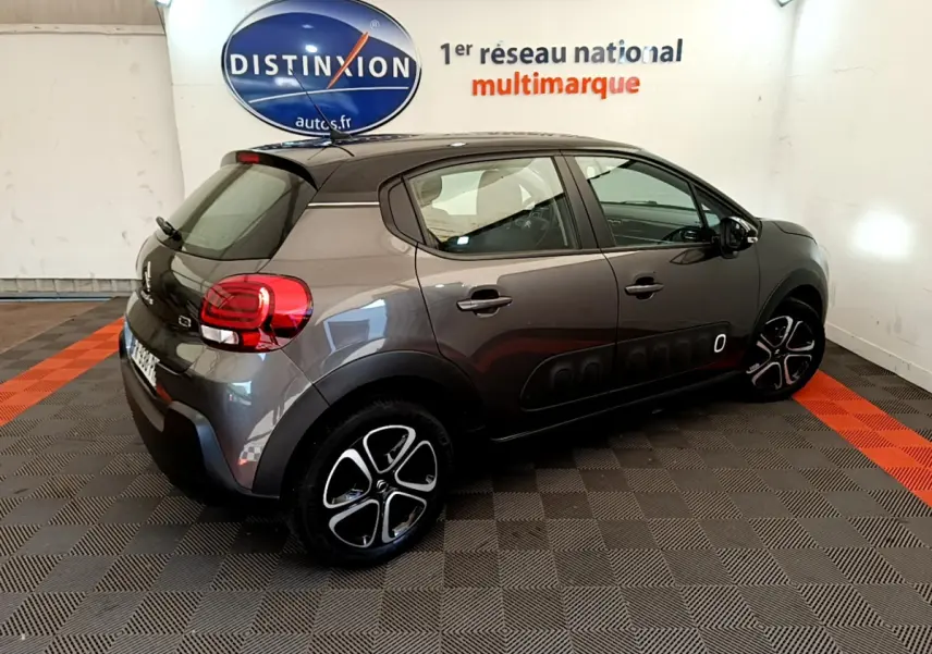 Citroën C3 gris foncé vue 3/4 arrière droit, avec protections latérales noires et jantes distinctives.