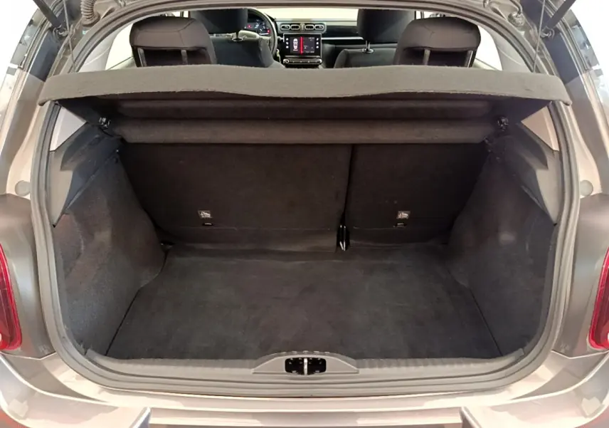 Coffre ouvert d'une Citroën C3 gris foncé vue de l'arrière, montrant l'espace de chargement et l'intérieur des sièges arrière.