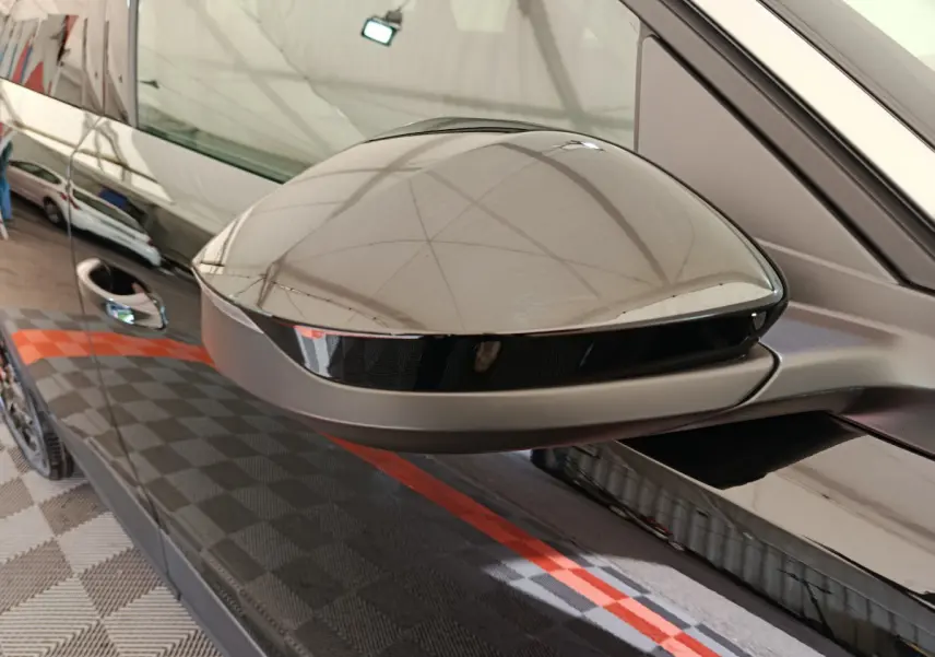 Rétroviseur droit noir brillant du Peugeot 3008 1.2 Hybrid 145 GT, avec reflet du capot et porte côté droit.