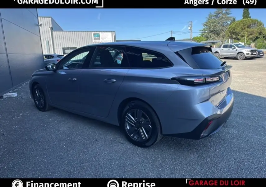 Peugeot 308 BlueHDi 130 gris clair vue 3/4 arrière droit, feux arrière LED et jantes alliage noires.