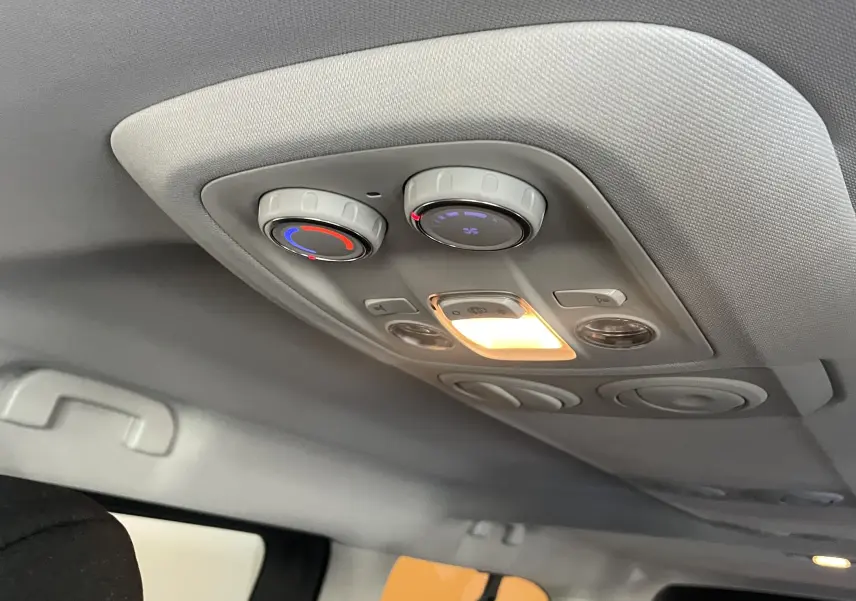 Vue intérieure du plafond arrière du Peugeot Traveller 2026 noir, montrant les commandes de climatisation et l'éclairage intégré.