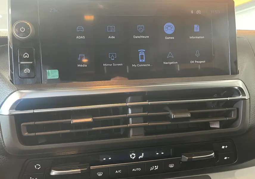 Vue rapprochée de l’écran tactile central et des commandes de climatisation du Peugeot Traveller noir, intérieur moderne et fonctionnel.