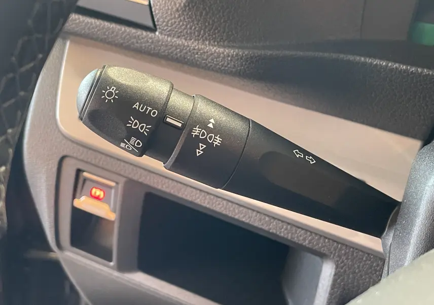 Gros plan sur la commande des feux et clignotants noire dans l’habitacle du Peugeot Traveller 2026, version Business.