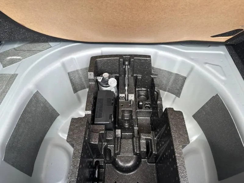 Rangement en mousse noire dans le coffre d'une Skoda Scala gris argent, vue plongeante sur l'espace de rangement.
