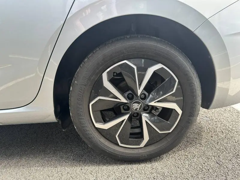 Gros plan sur la roue arrière droite gris argent métallisée d'une Skoda Scala 2025 avec jante alu au design géométrique noir et argent.