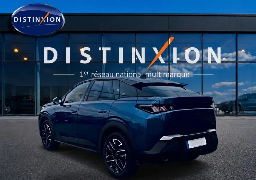 Peugeot 3008 bleu 3/4 arrière droit, avec jantes alu et feux arrière LED, devant un showroom Distinxion.